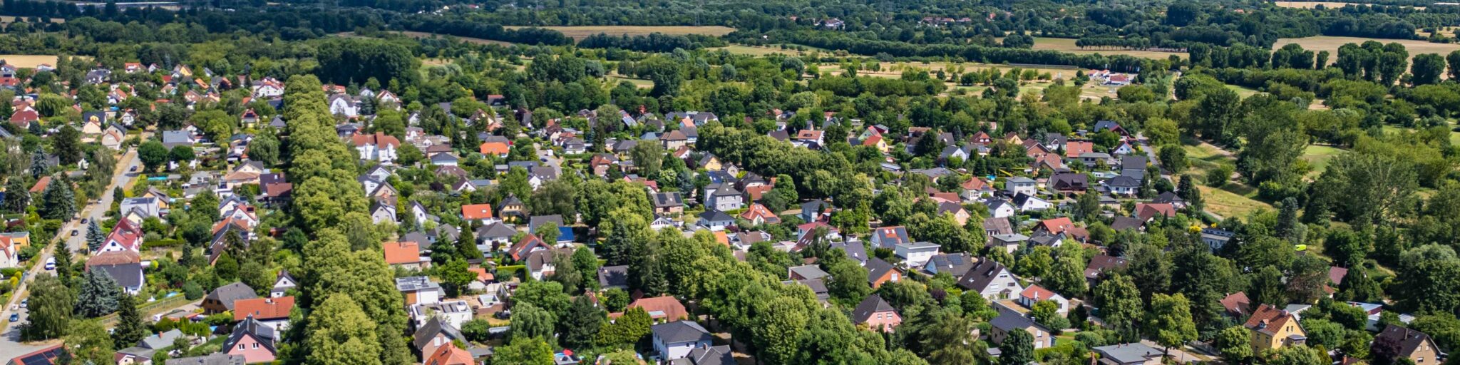 Panoramablick über Wohnhäuser, Gärten und baumreiche Straßen